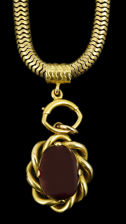 A Victorian gold snake link chain, hung with a gold and single stone oval cabochon garnet set mourning pendant